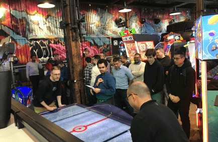 Information Security team socializing with a round of air hockey.