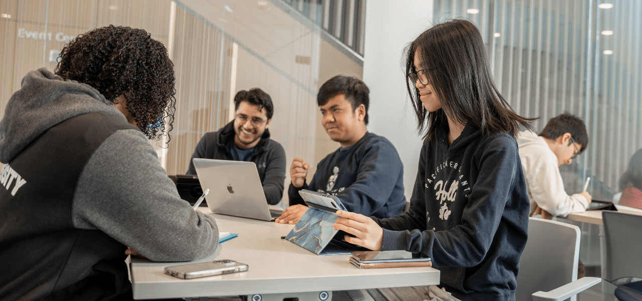 A group of students using digital devices in a study area.